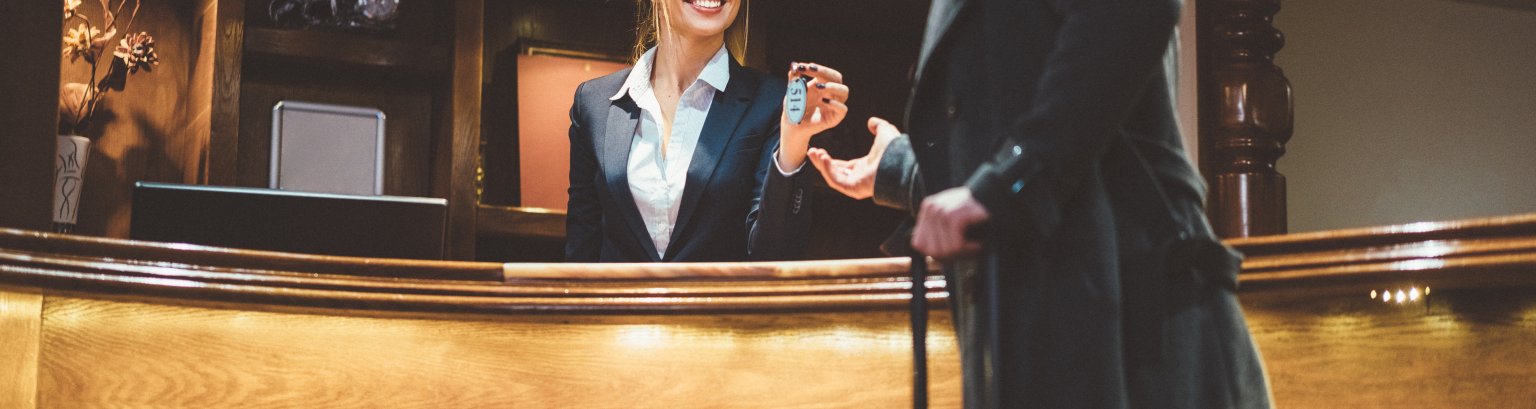 Receptionist giving keys to hotel guest