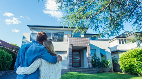 Couple standing in front of their new home. Couple standing in front of their new home.