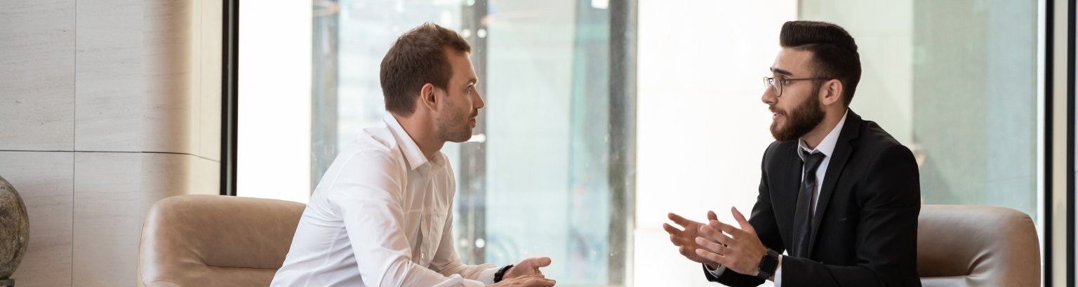 Middle eastern and caucasian ethnicity businessmen talking negotiating indoors